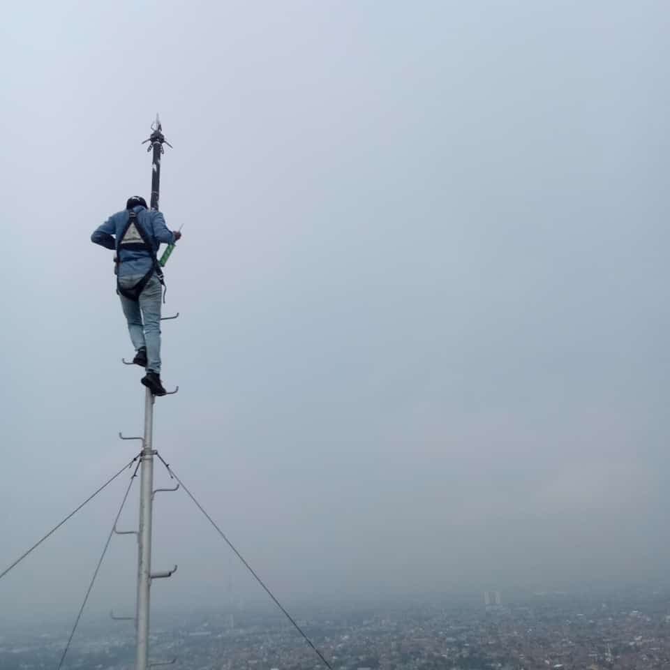 Teknisi memasang head terminal penangkal petir di puncak tiang
